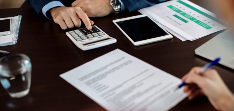 Consultant calculating VAT registration costs and reviewing agreement documents in Dubai